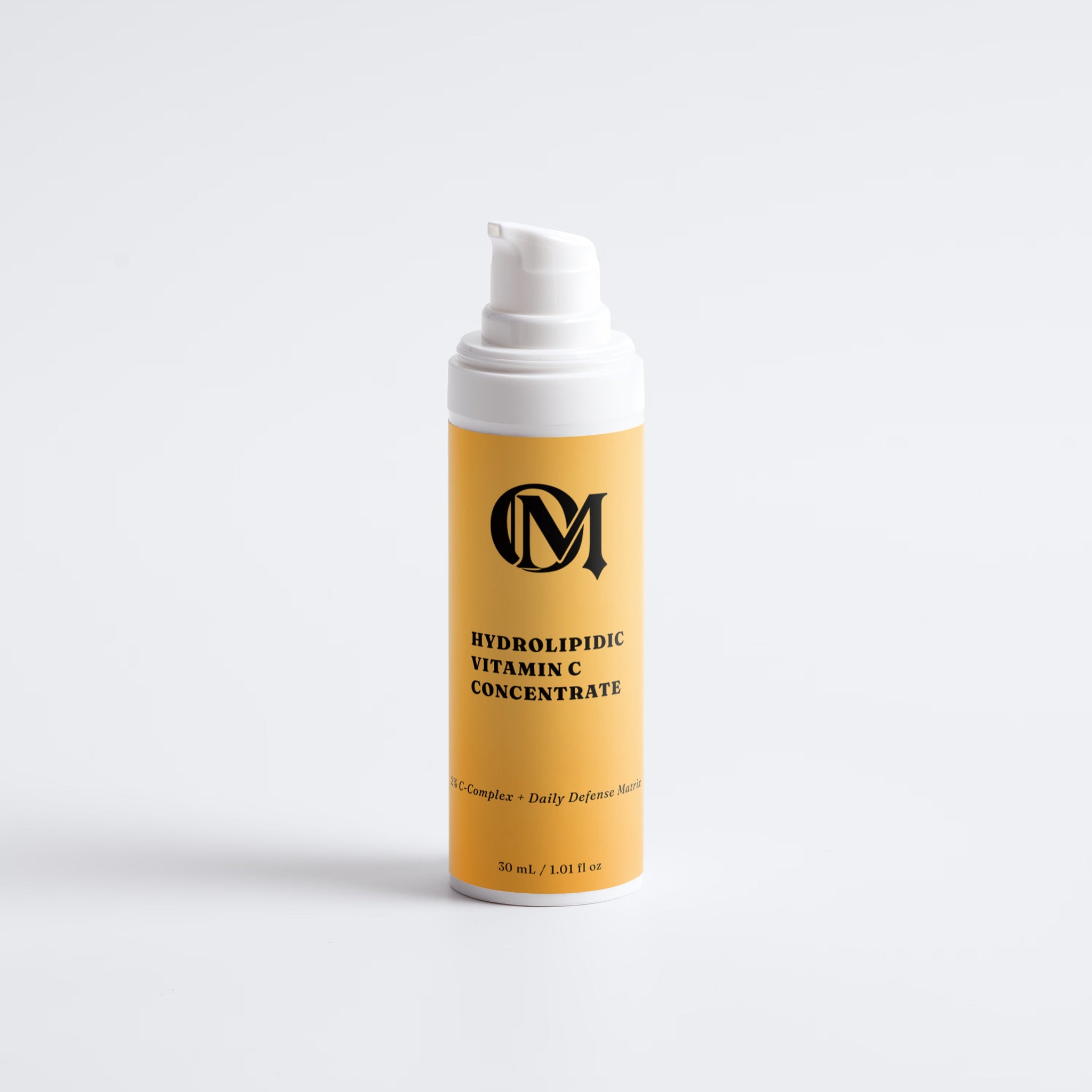 A 30 mL pump bottle of OM Hydrolipidic Vitamin C Concentrate, featuring a mustard yellow label with black text and logo, and a white pump dispenser, set against a clean white background.