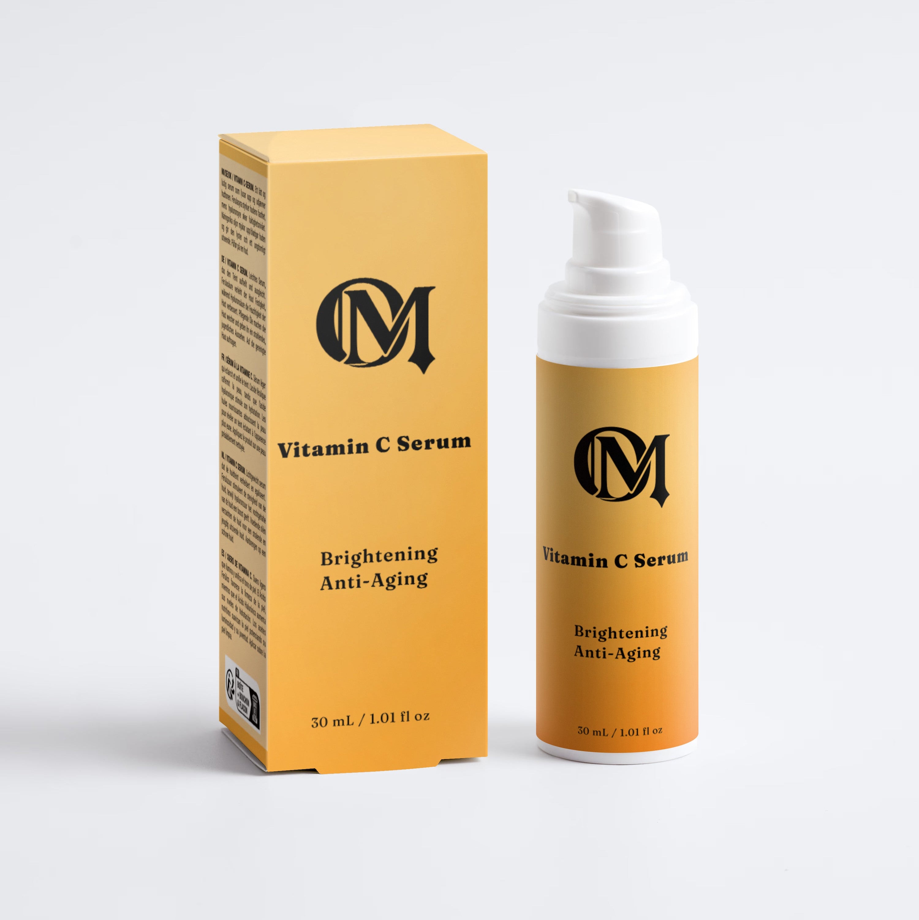 A Vitamin C Serum bottle with a white pump and a matching yellow-orange box, both featuring a black circular 'M' logo and text, set against a light gray background.